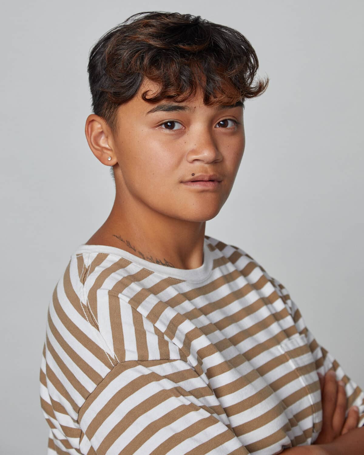 Young man with wavy, dark, short hair eating brownie, anime